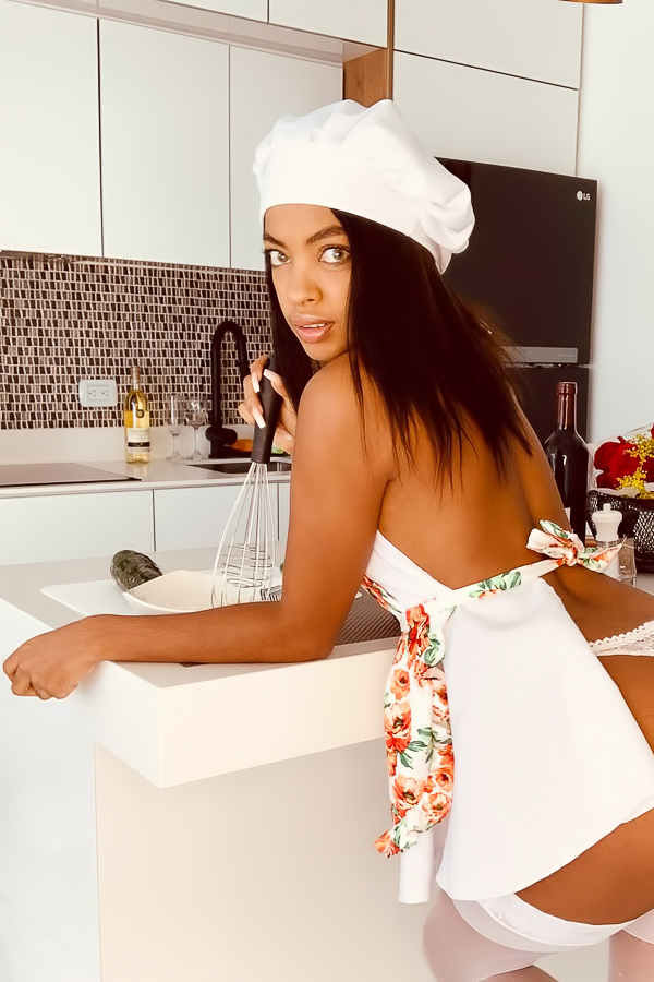 Sofi Vega naked in the kitchen, white stockings and chef hat, posing with a bottle, red heels on